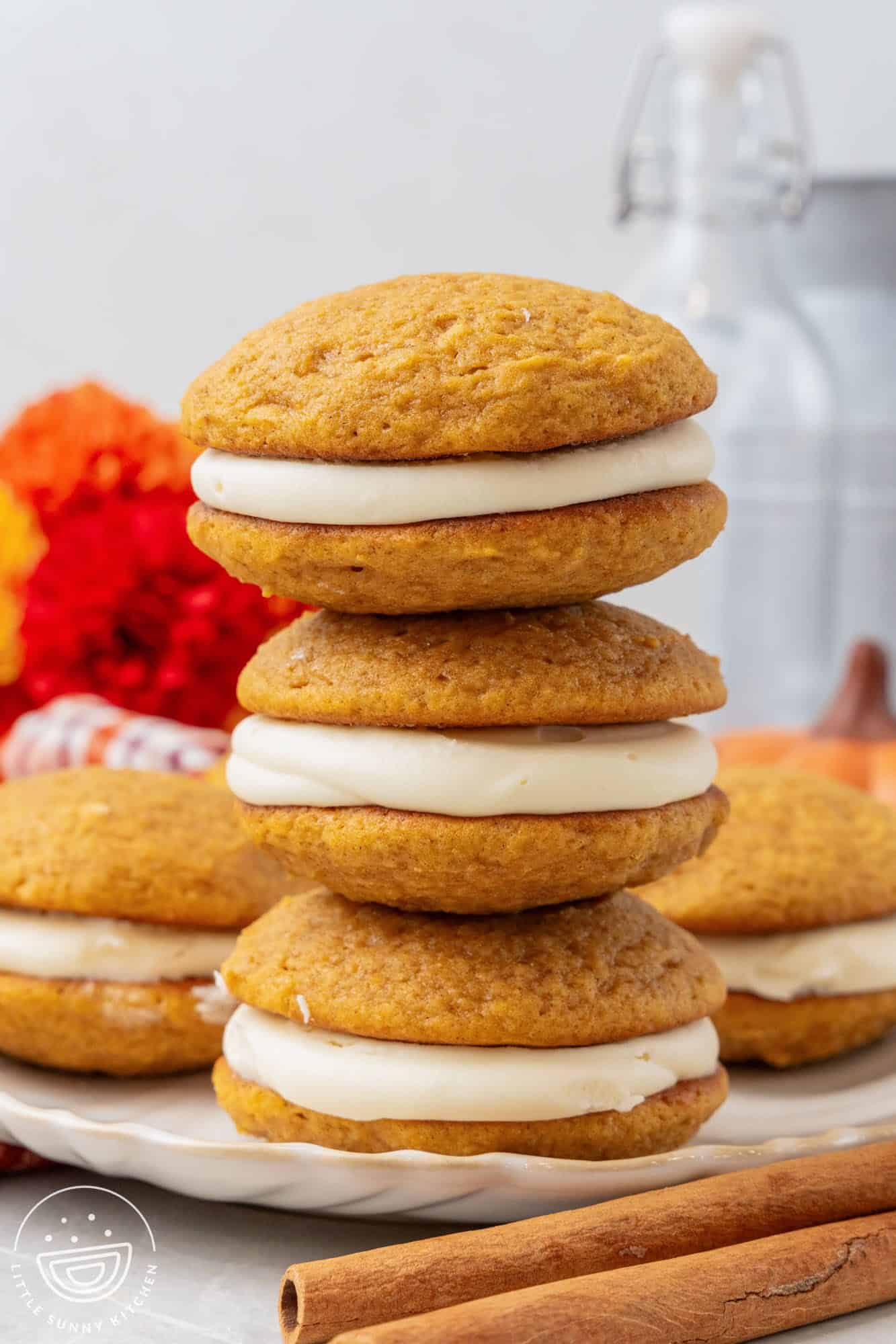 a stack of three pumpkin whoopie pies on a platter.