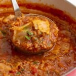 closeup of a ladle serving stuffed cabbage soup.