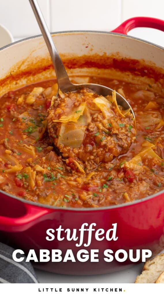 A red pot of beefy stuffed cabbage soup. A ladle is holding some up.