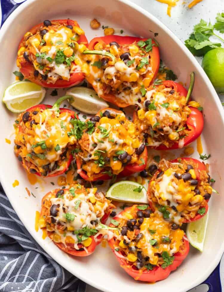 an oval casserole filled with cheese covered vegetaraian stuffed peppers.
