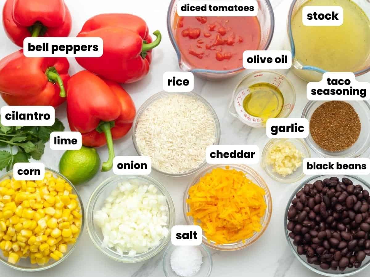The ingredients needed to make vegetarian stuffed peppers with rice, beans, and corn