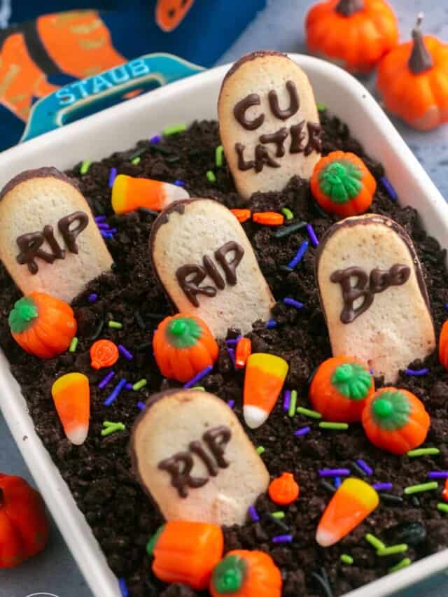 Angle shot of Graveyard Chocolate Cheesecake Dip in a Staub dish, decorated with halloween candy and sprinkles