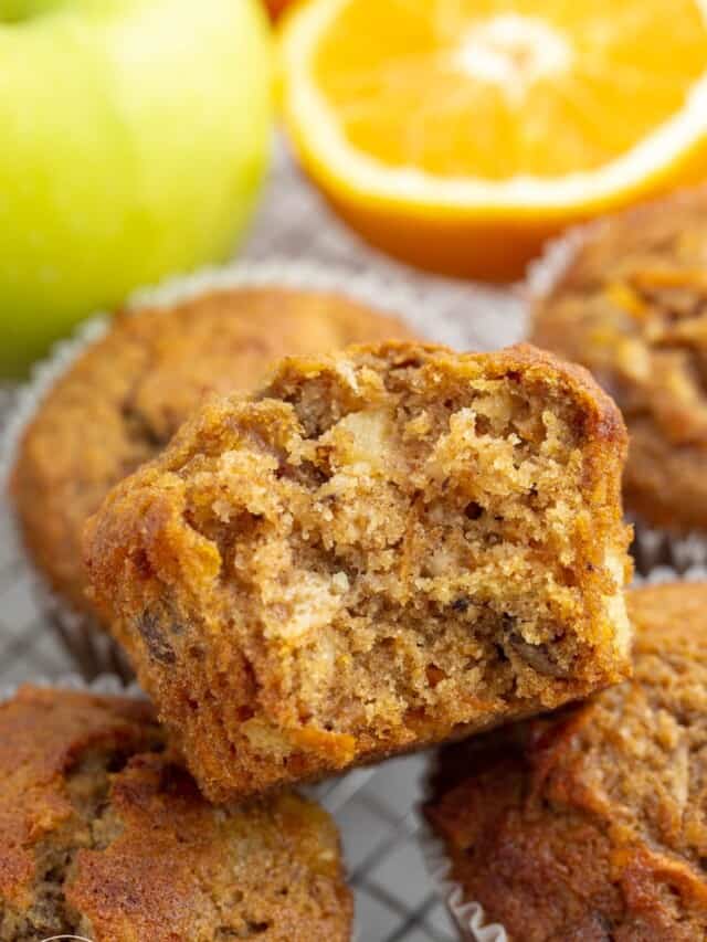 a morning glory muffin with a bite taken, to show the hearty and nutritious interior.