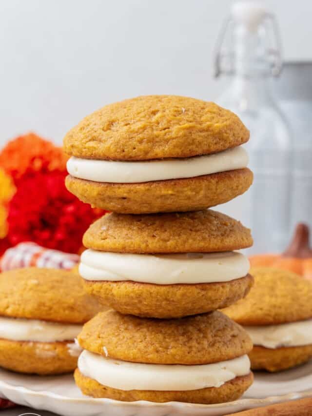 a stack of three pumpkin whoopie pies on a platter.
