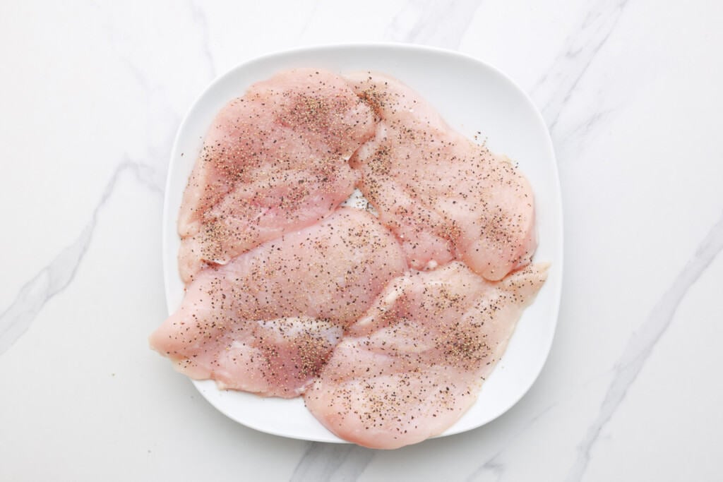 raw chicken breasts seasoned with salt and pepper. 