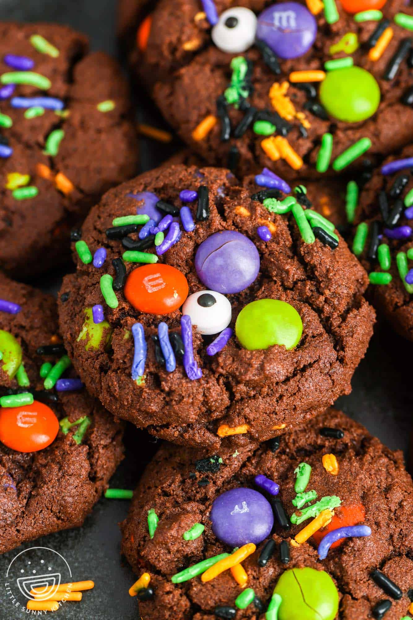 chocolate cookies with halloween sprinkles, orange, purple and green M&Ms and candy eyes.