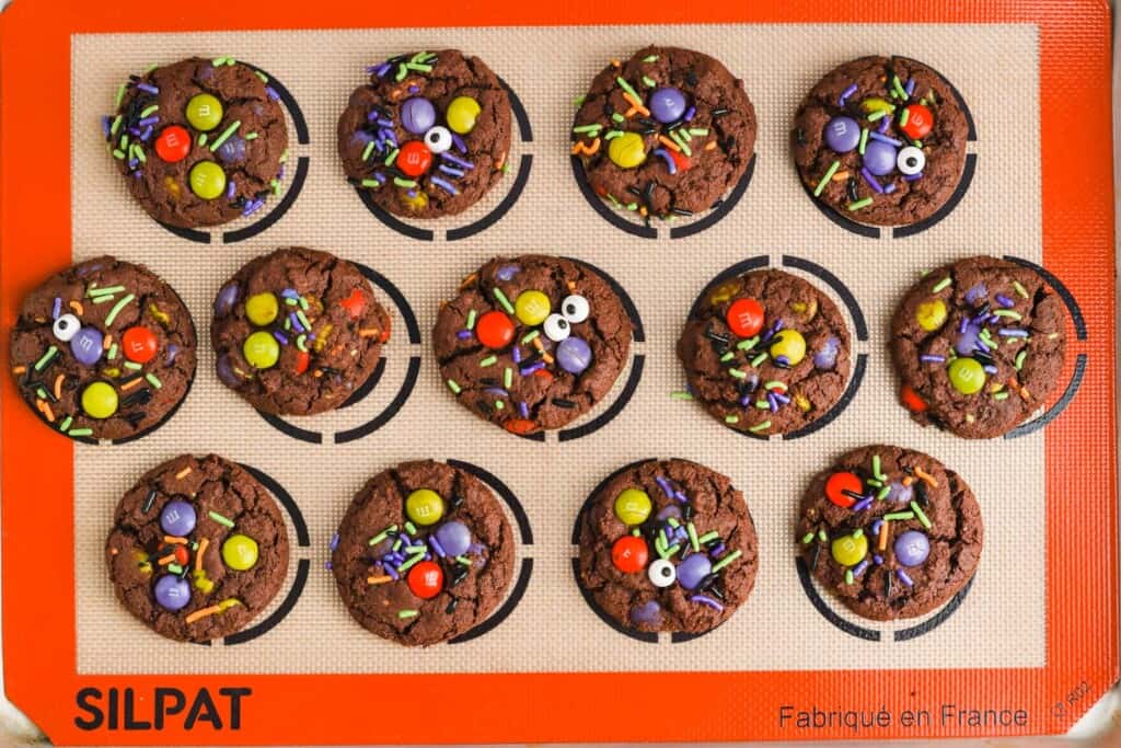 chocolate cookies with halloween decorations on a silpat cookie mat