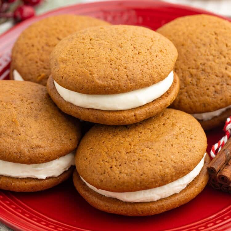 5 gingerbread whoopie pies on a red plate.