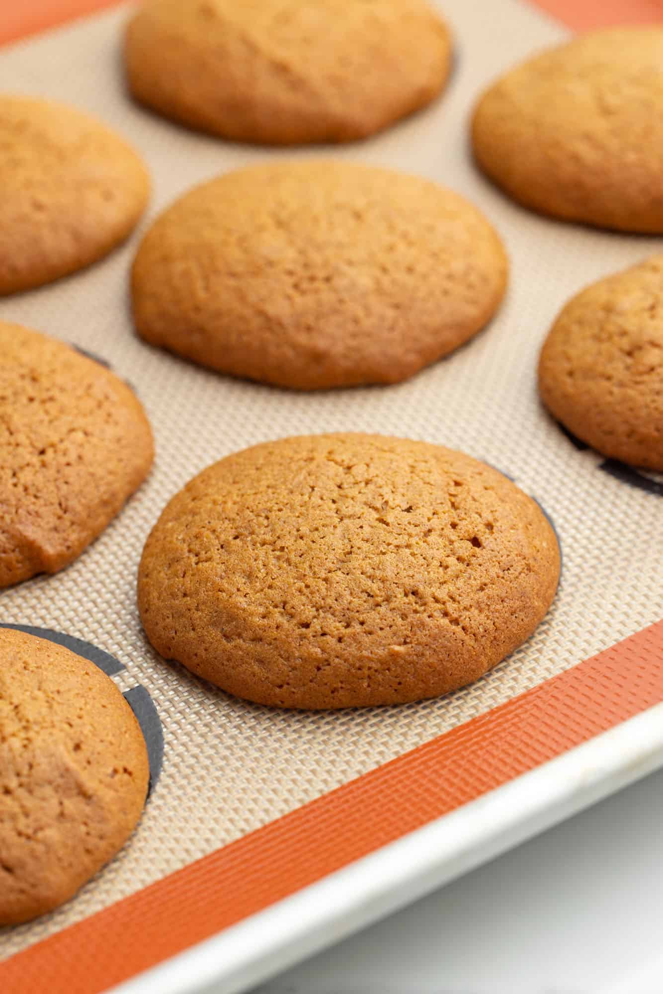 baked gingerbread whoopie pies on a baking sheet.