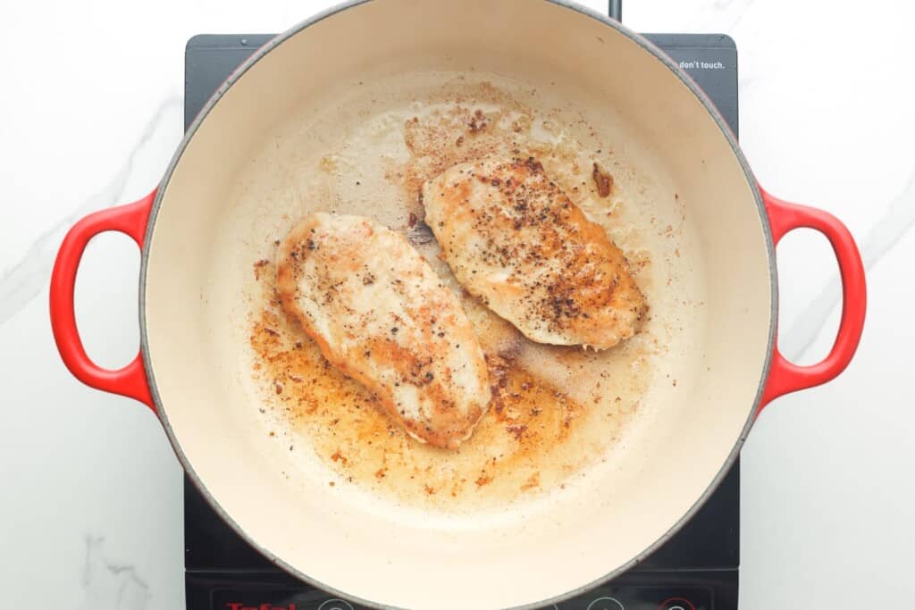 two chicken breasts cooked in a dutch oven.