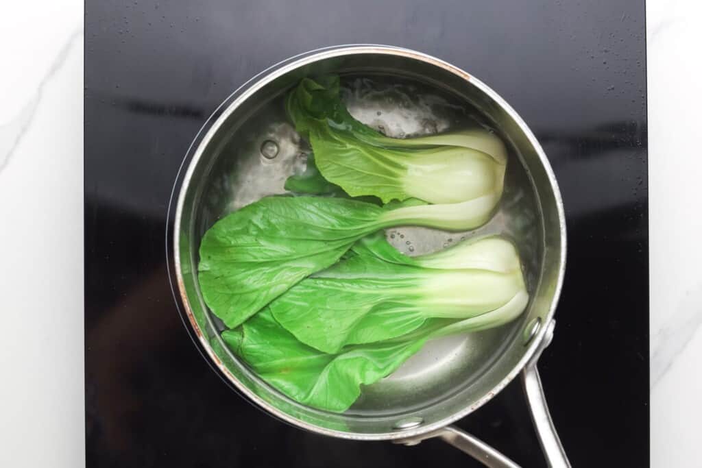 Baby bok choi blanched in a pot of water