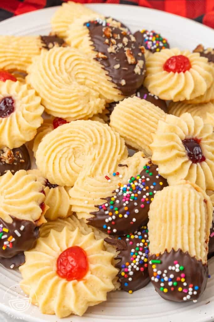 Ridged italian cookies dipped in chocolate, in different shapes, arranged on a platter.