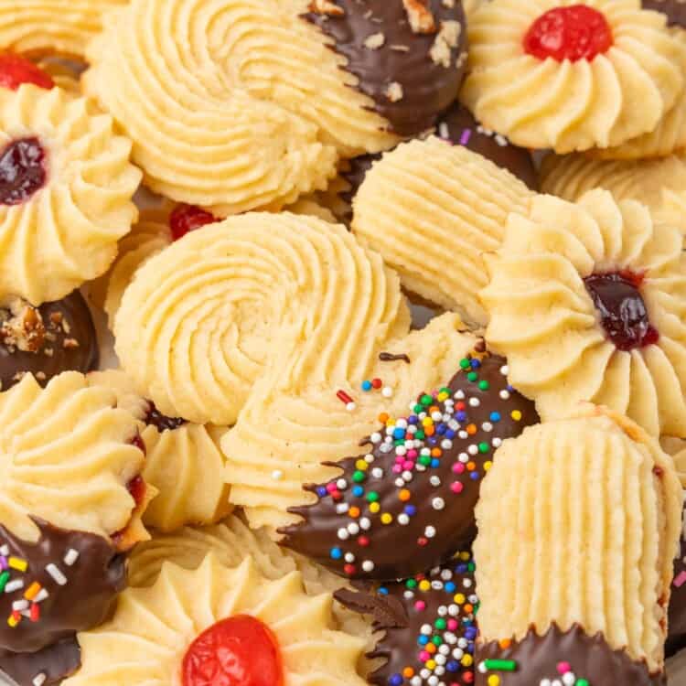 Ridged italian cookies dipped in chocolate, in different shapes, arranged on a platter.