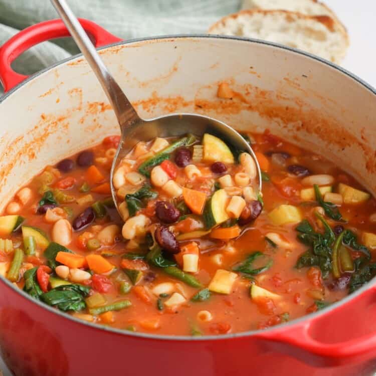 a ladle holding up a serving of homemade minestrone