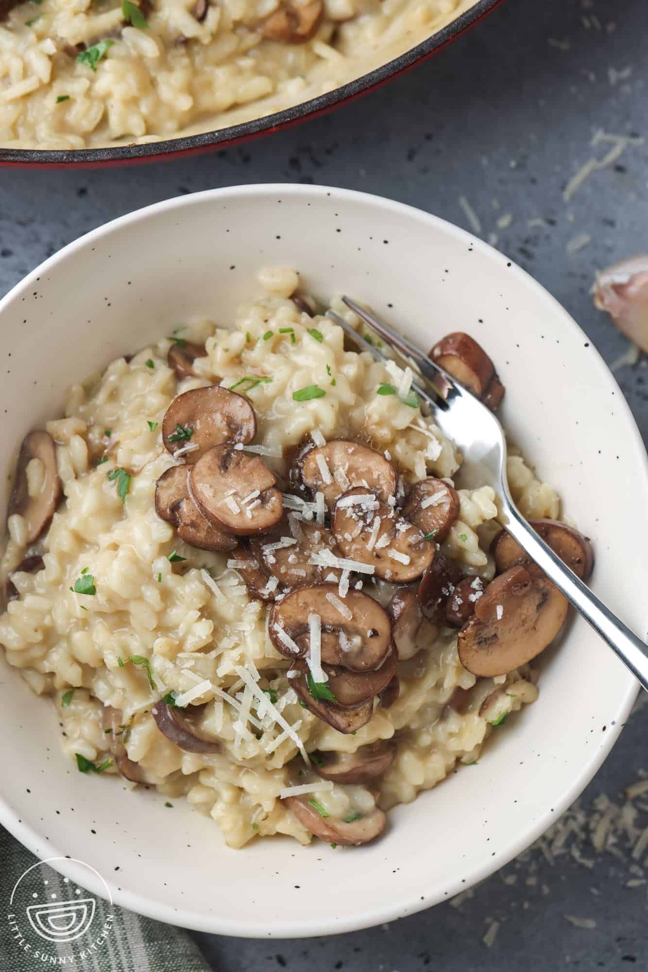 Overhead shot of mushroom risotto in a bowl with a fork