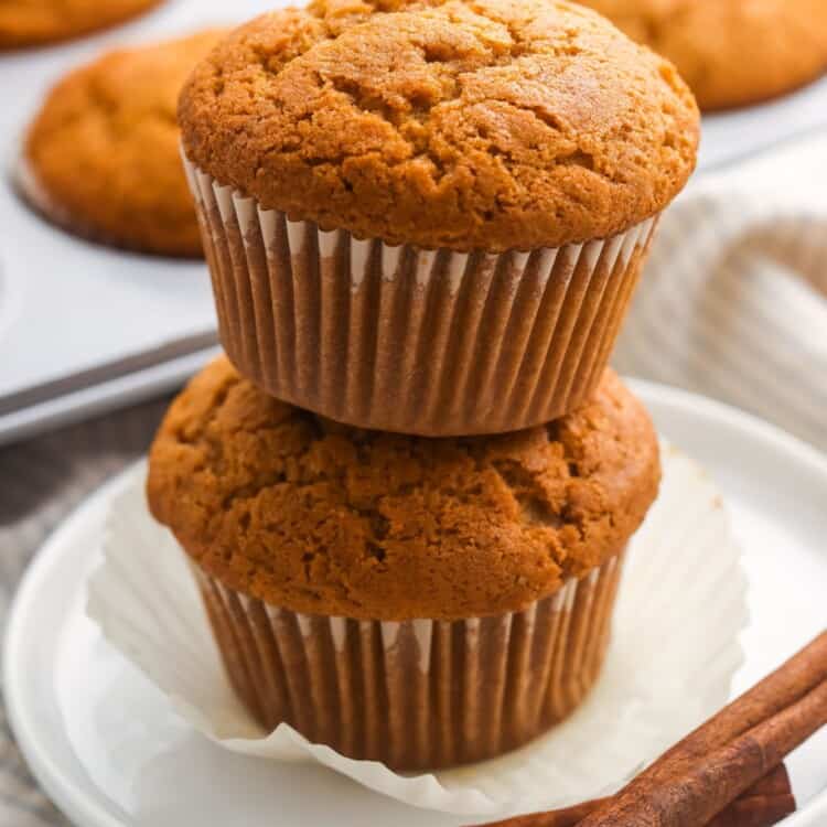 two banana pumpkin muffins stacked on top of each other.