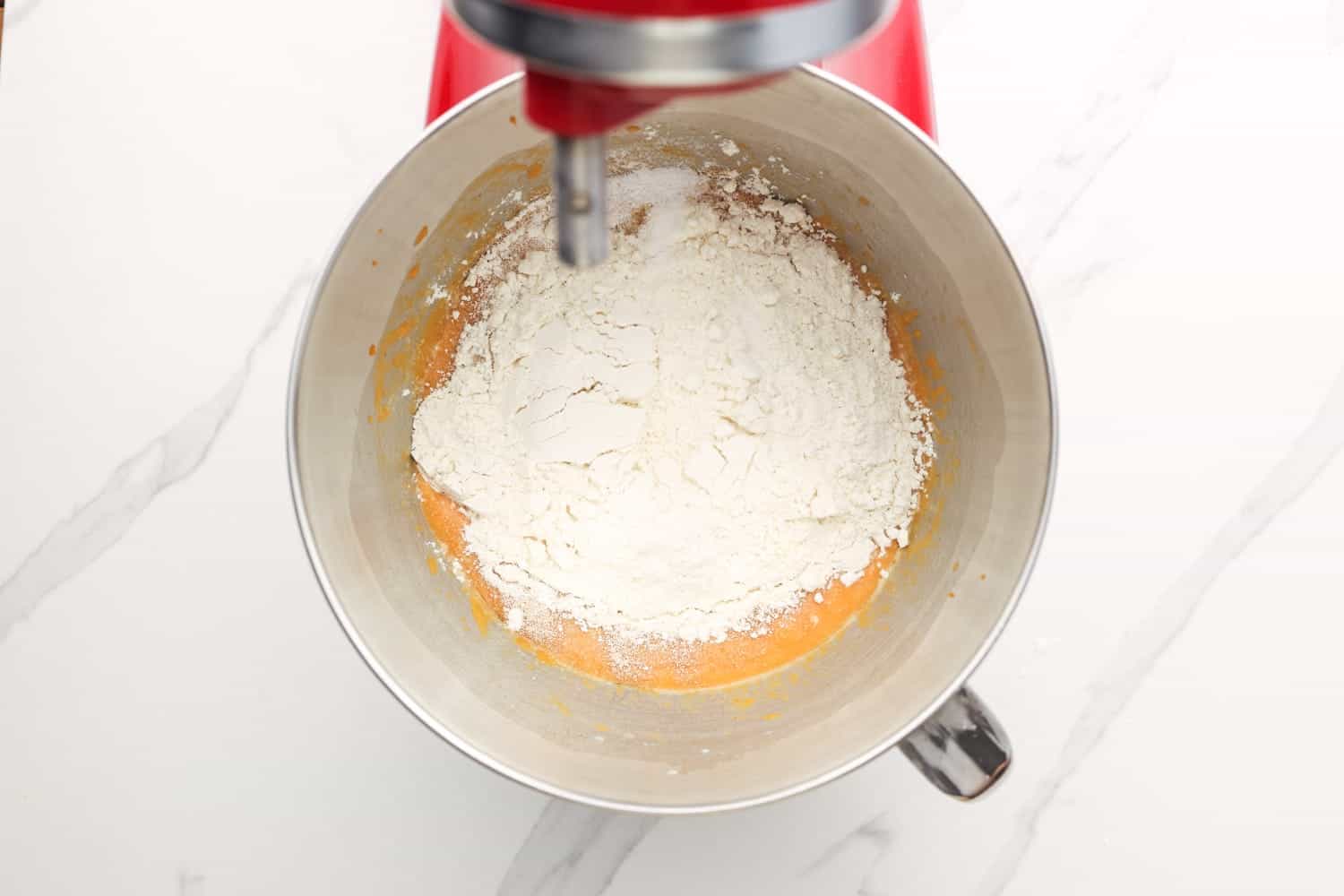 Flour and yeast added to a mixer.