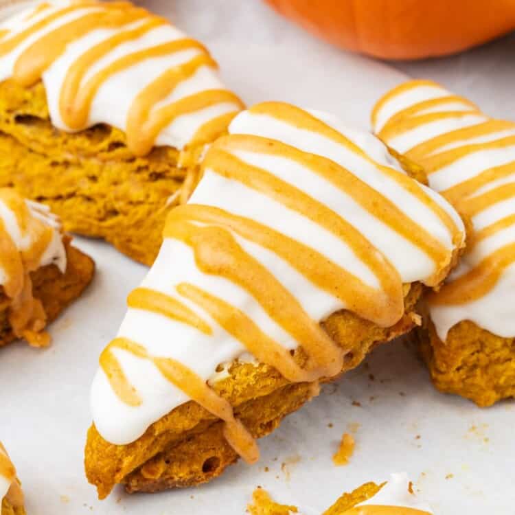 triangle shaped pumpkin spice scones on a baking tray lined with parchment paper.