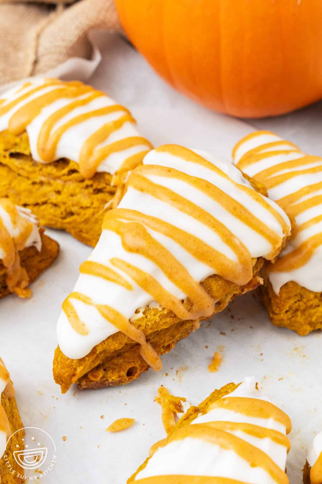 triangle shaped pumpkin spice scones on a baking tray lined with parchment paper.