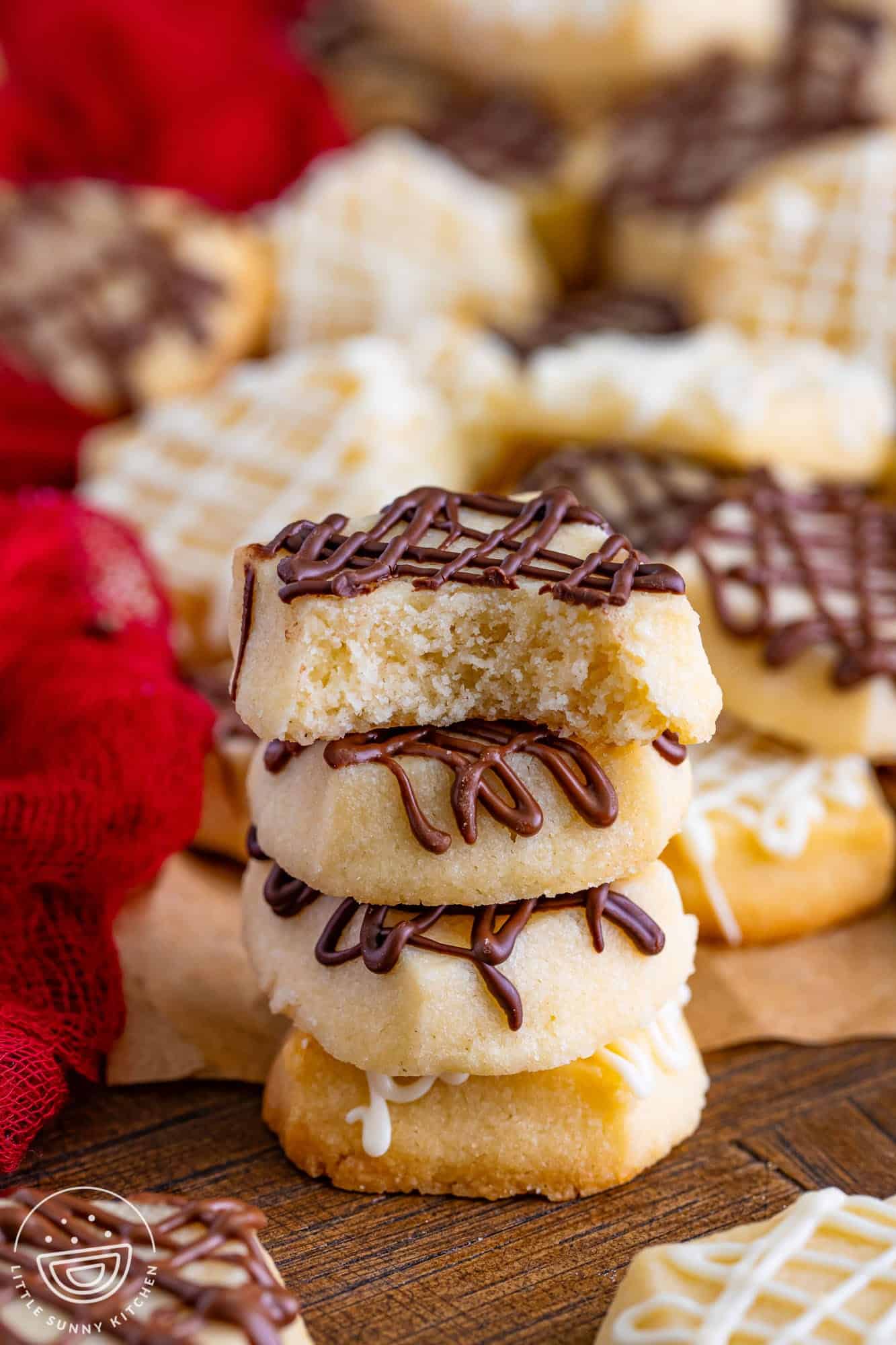 a stack of four mini shortbread cookies with melted chocolate.