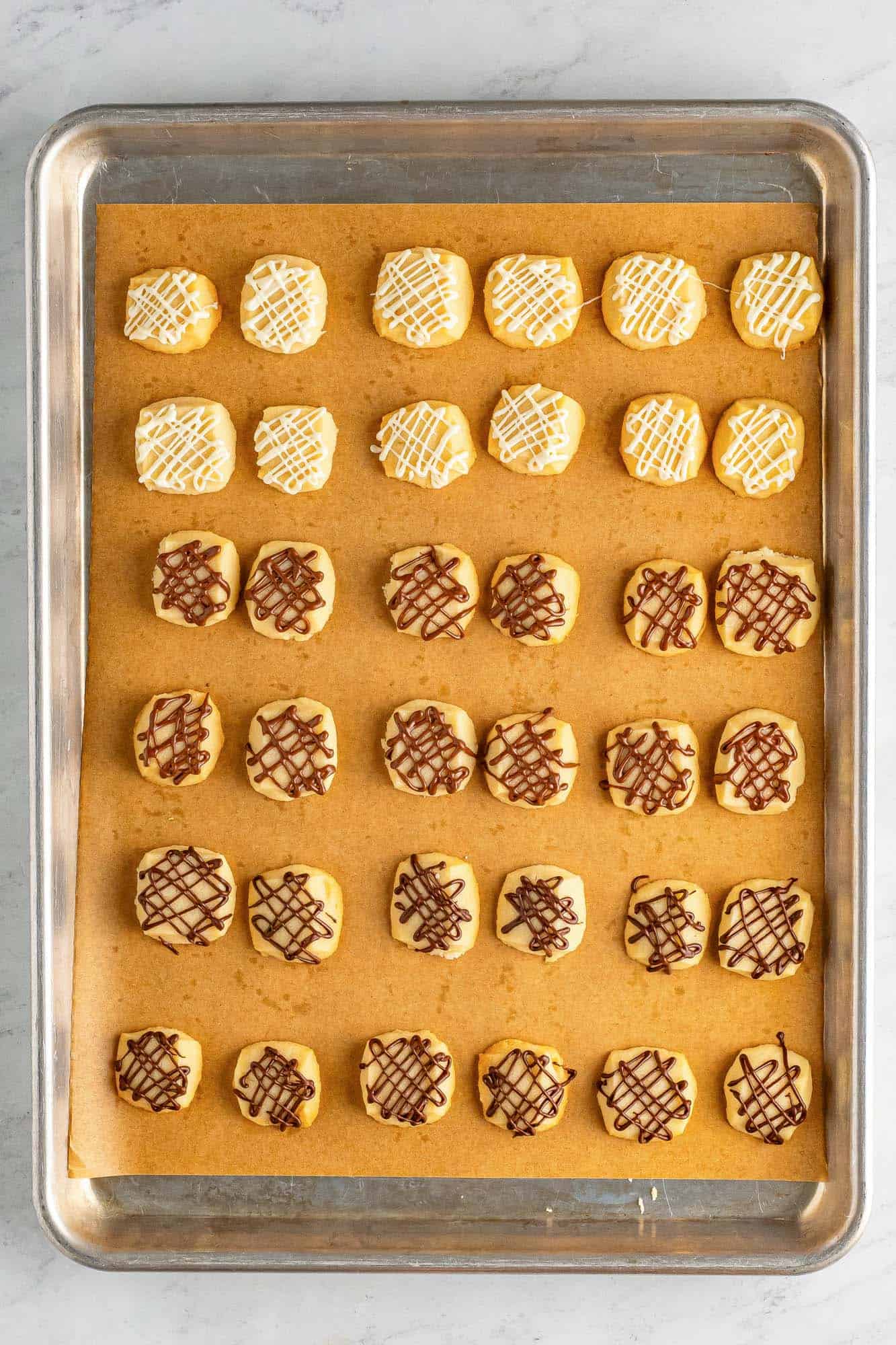 shortbread bites on a tray, all have been drizzled with chocolate.