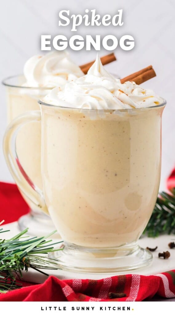 a mug of creamy eggnog with whipped cream. Text overlay says "spiked eggnog"