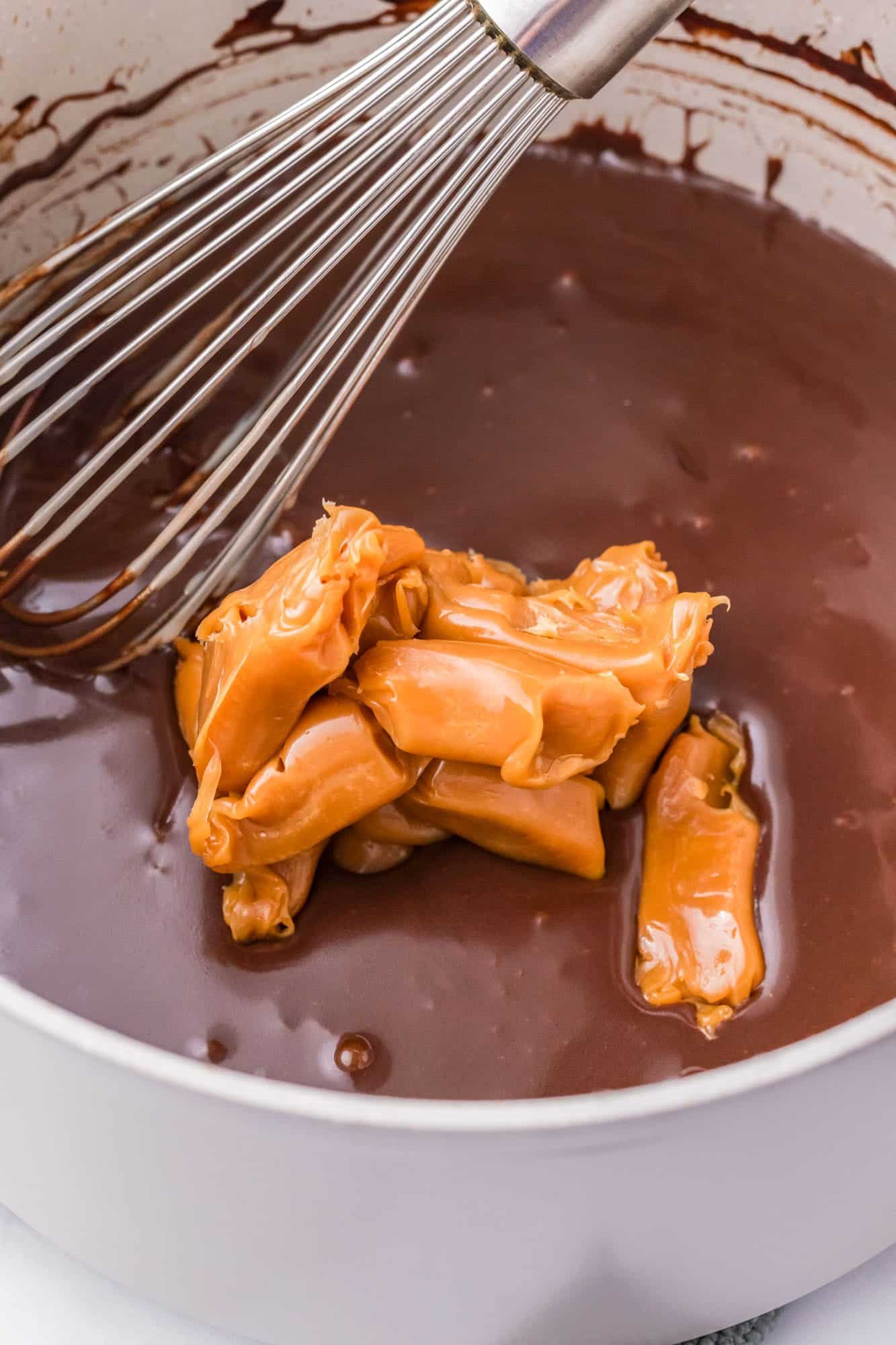 soft caramels stirred into a chocolate mixture in a pan.