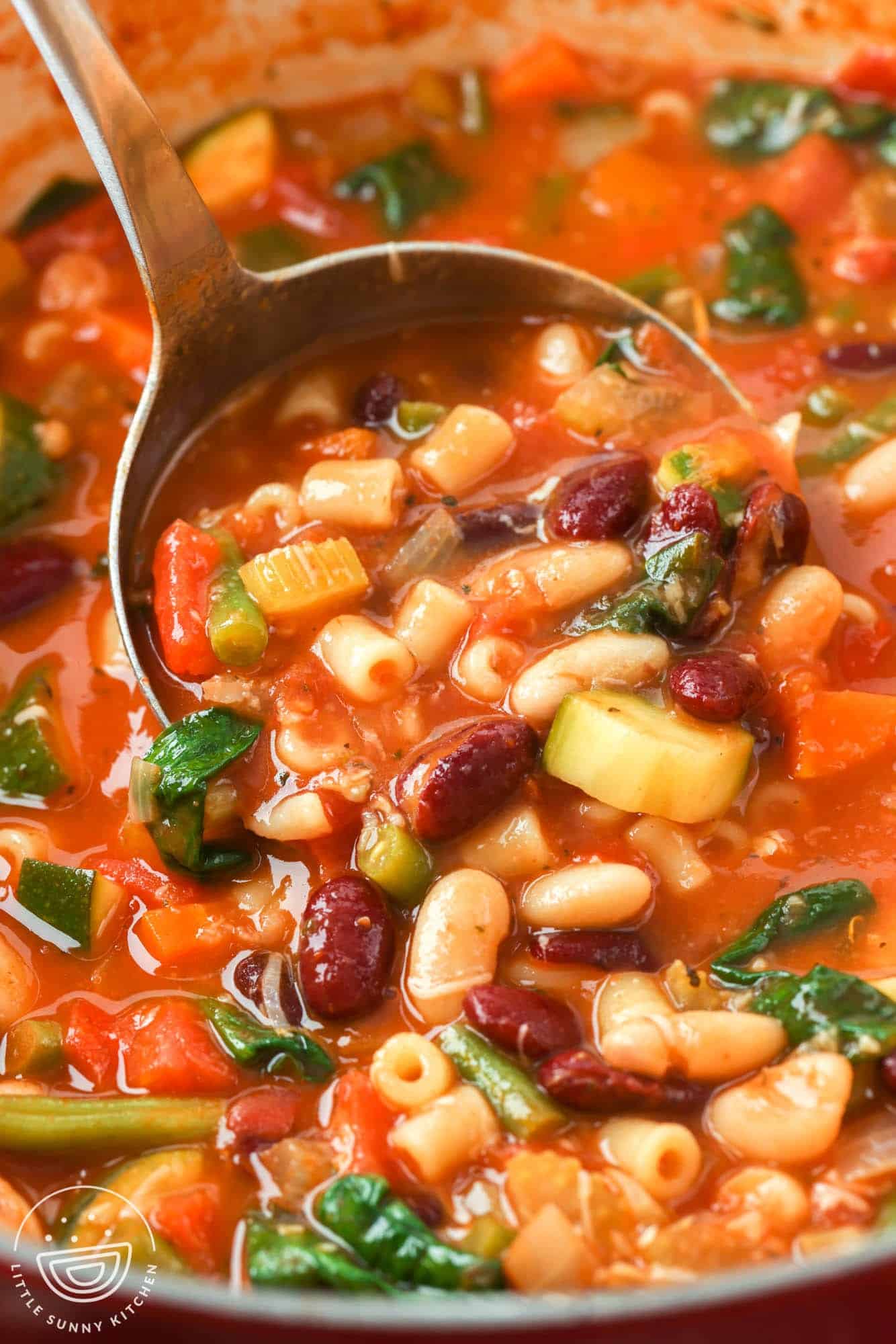 closeup of a pot of minestrone soup with beans and vegetables.