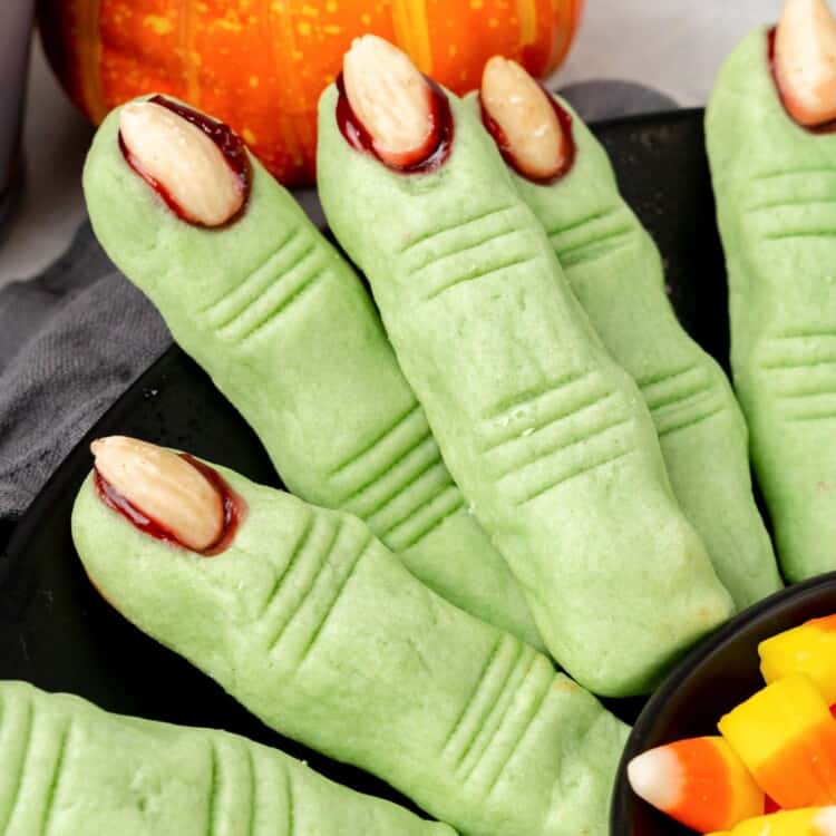 green cookies shaped with witch fingers with bloody fingernails.