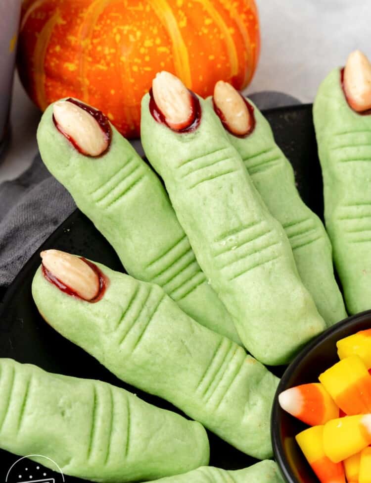 green cookies shaped with witch fingers with bloody fingernails.