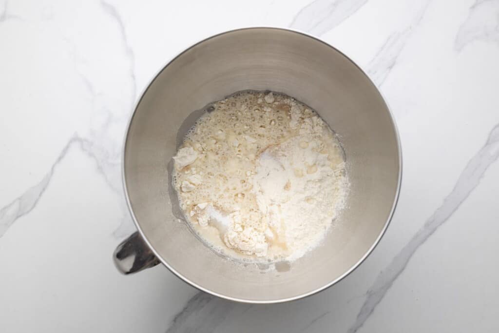 Dough ingredients in a bowl of a stand mixer before kneading