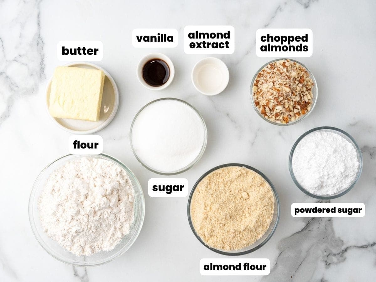 the ingredients for Almond crescent cookies, all in separate bowls on a counter.