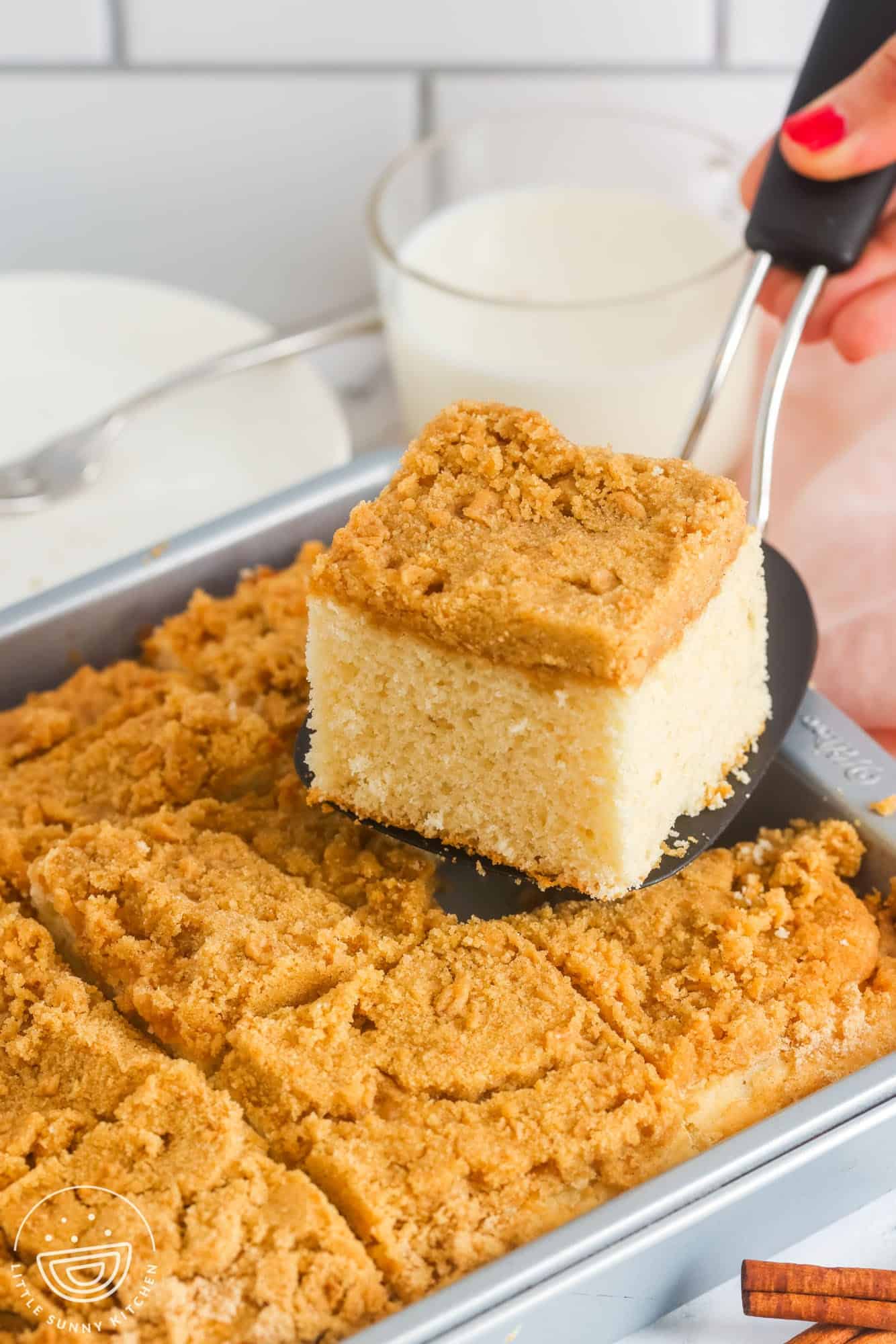 a spatula picking up a slice of bisquick coffee cake from the pan.