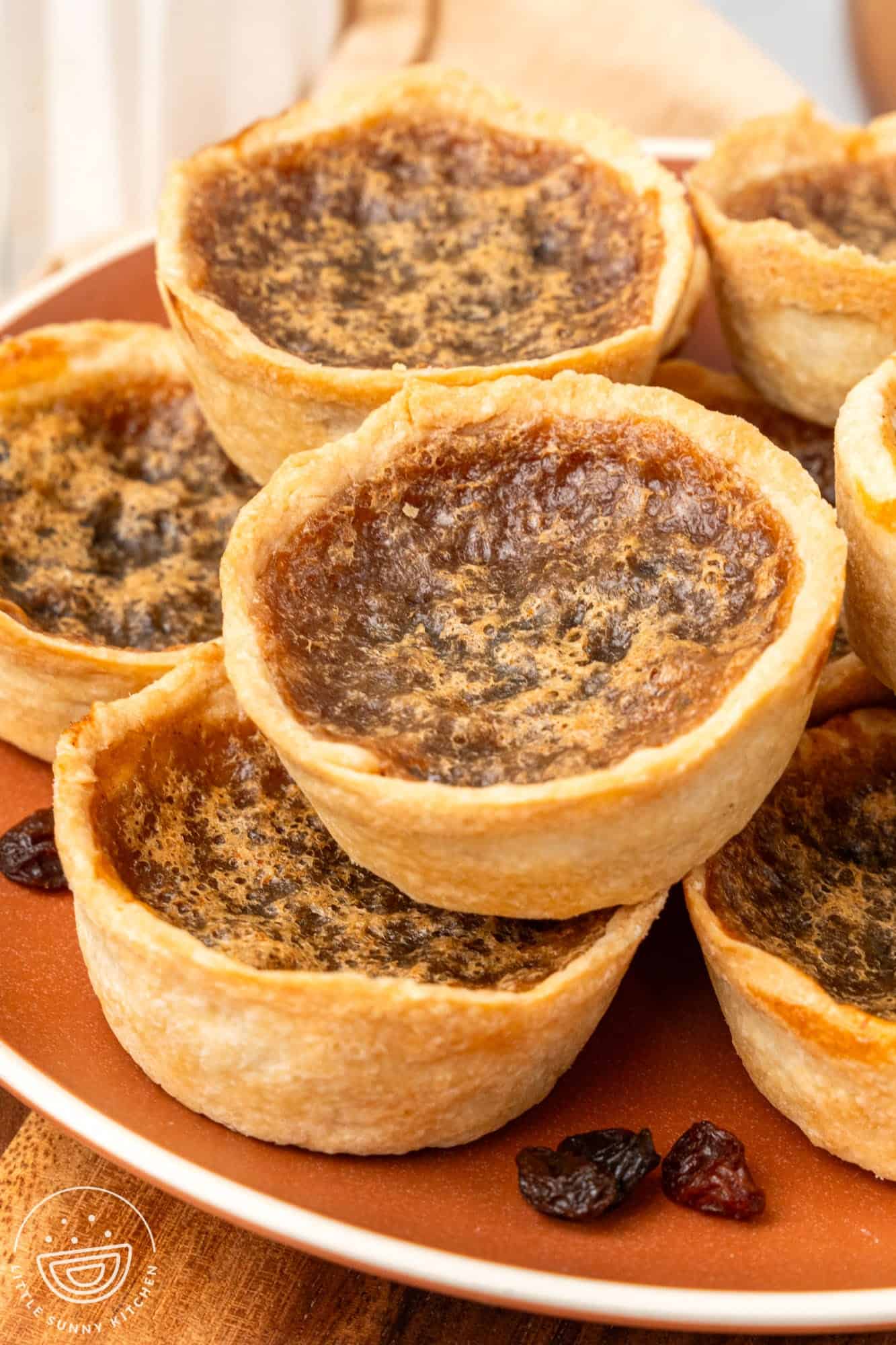 a plate of canadian butter tarts with raisins on the plate