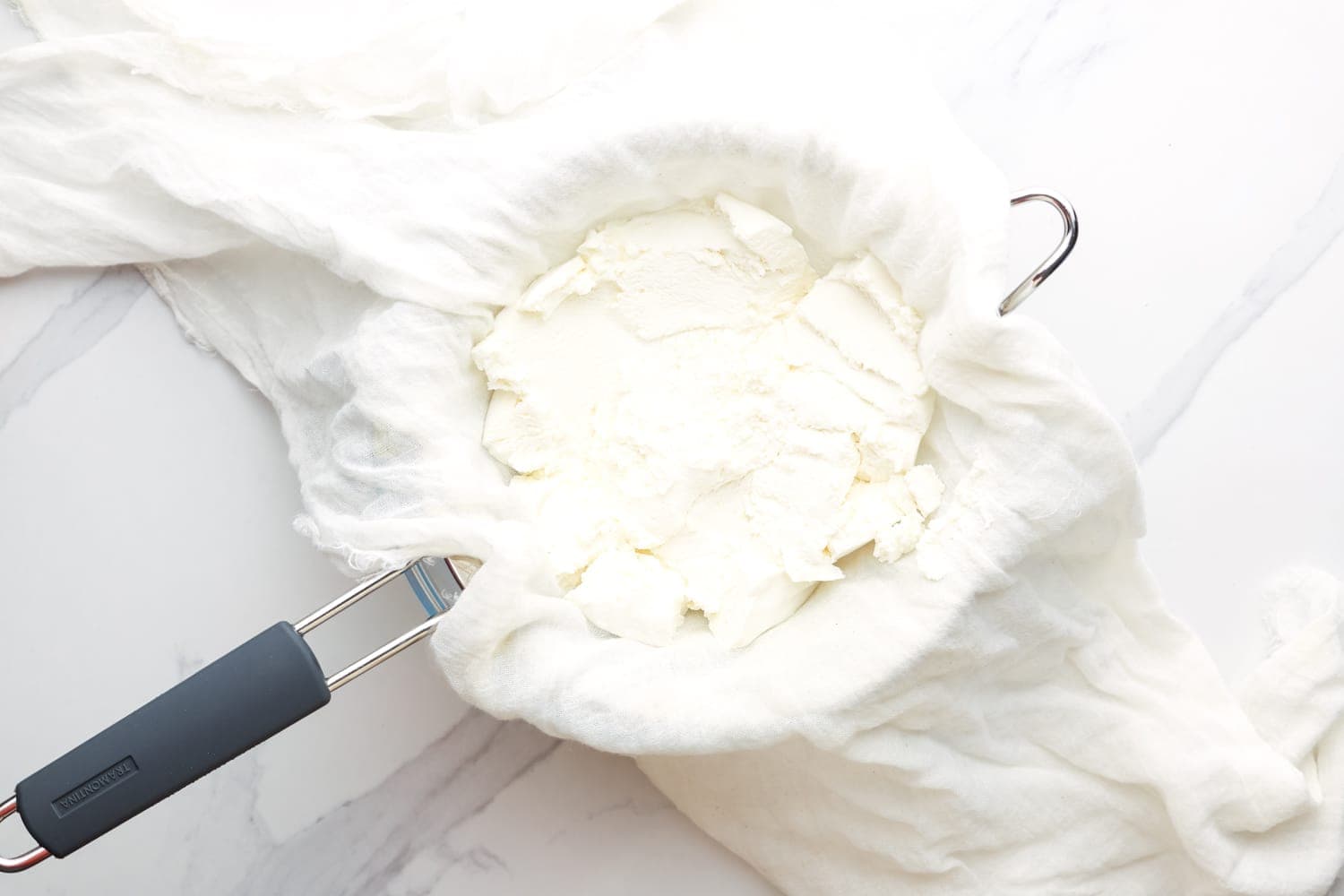ricotta cheese strained in cheesecloth. 