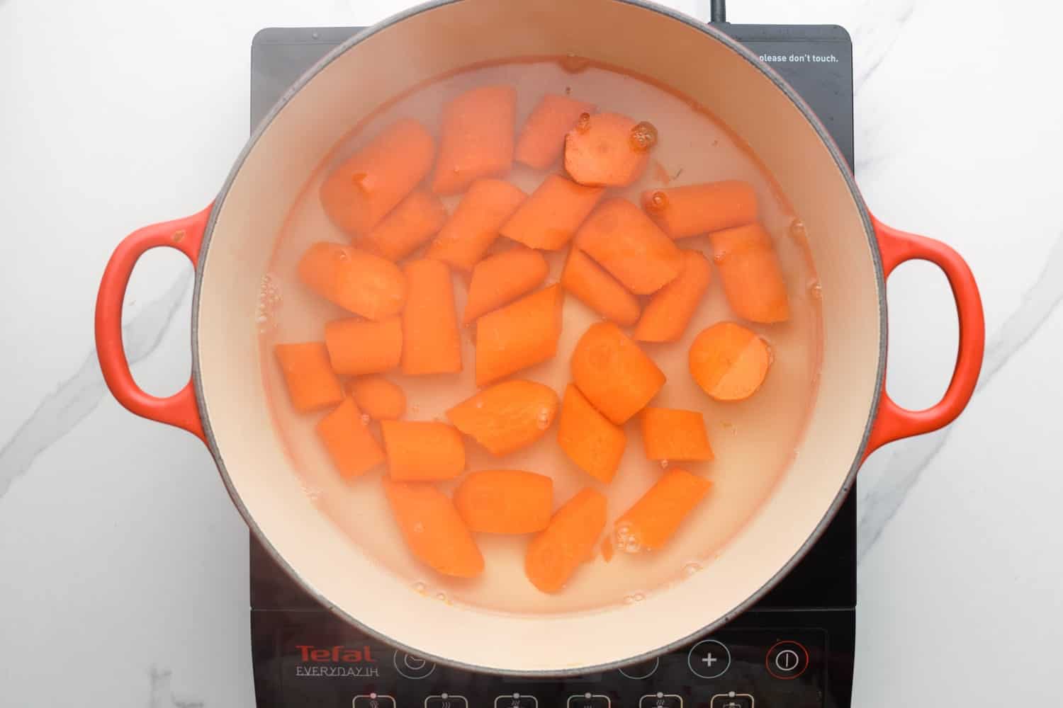 Carrot being boiled in a dutch oven