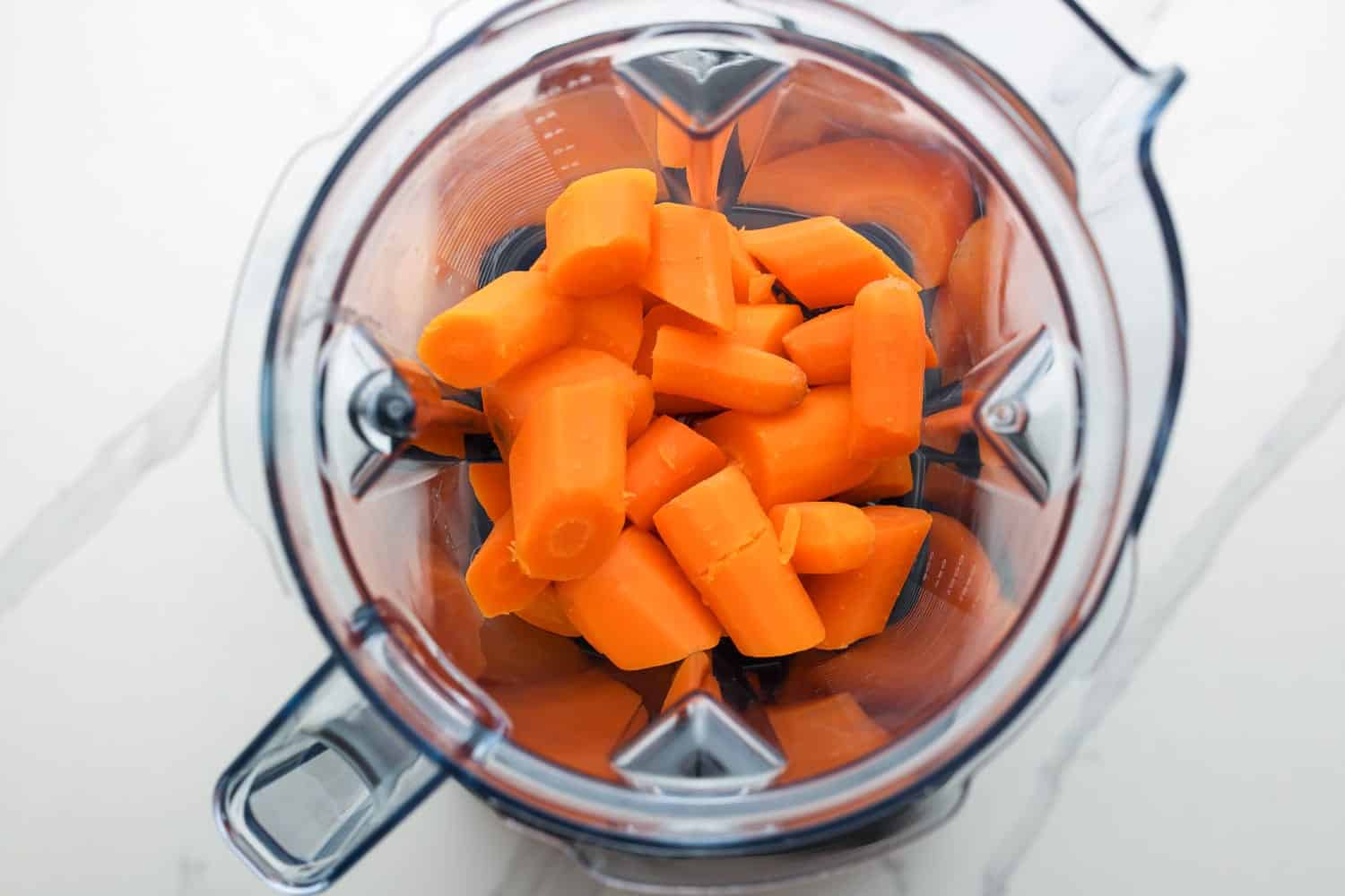 Cooked carrot in a blender jug before blending