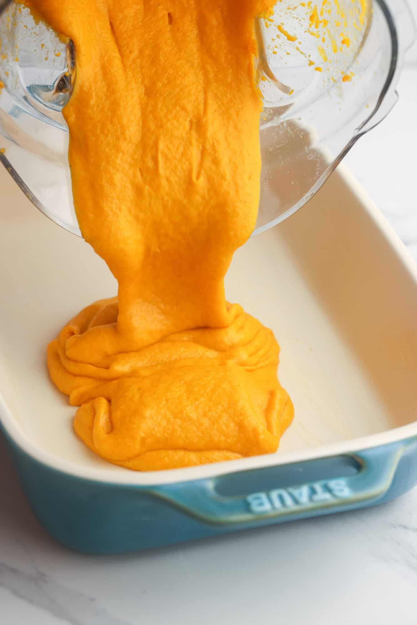 Pouring carrot souffle mixture to a baking dish