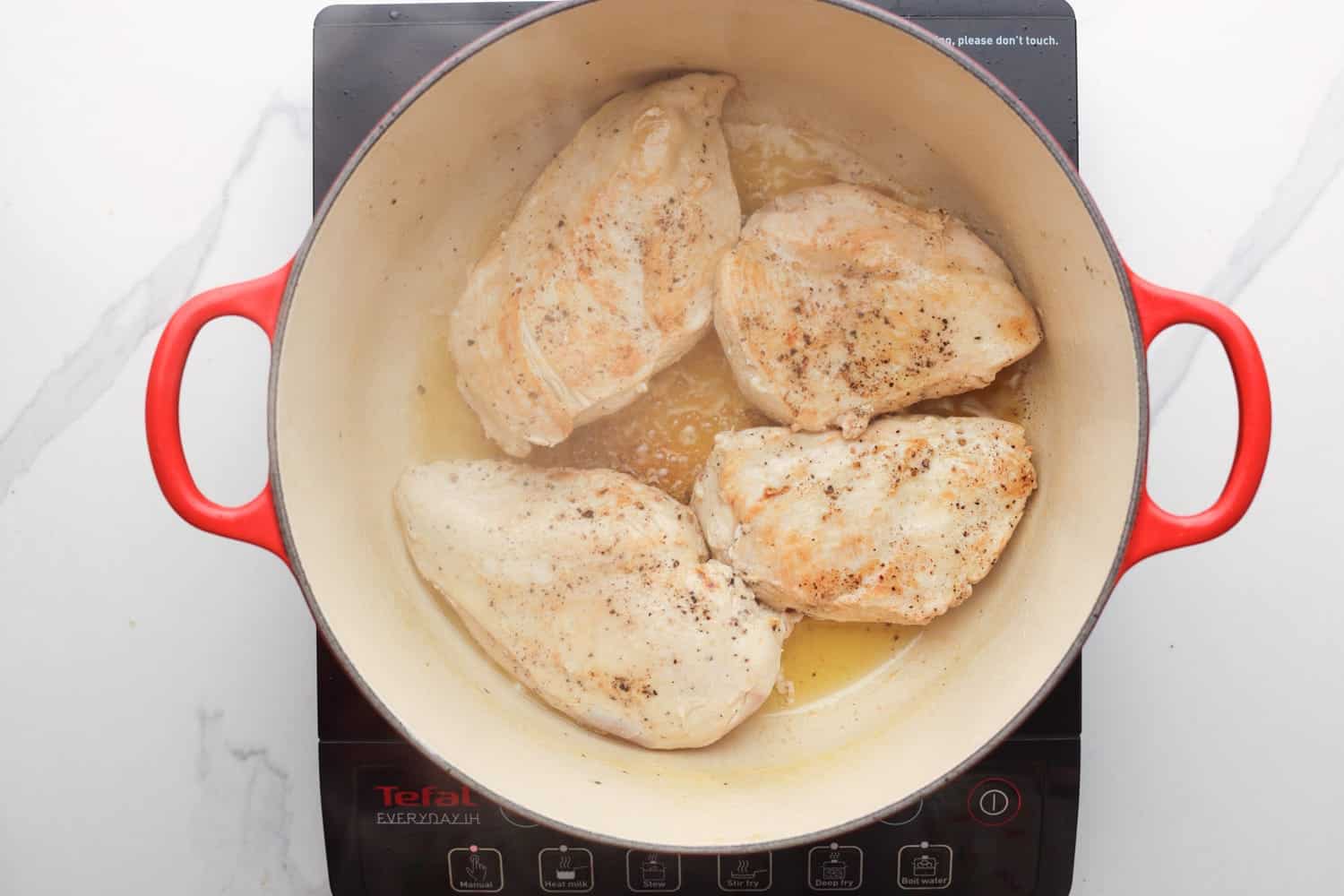 cooked chicken breasts in a dutch oven.