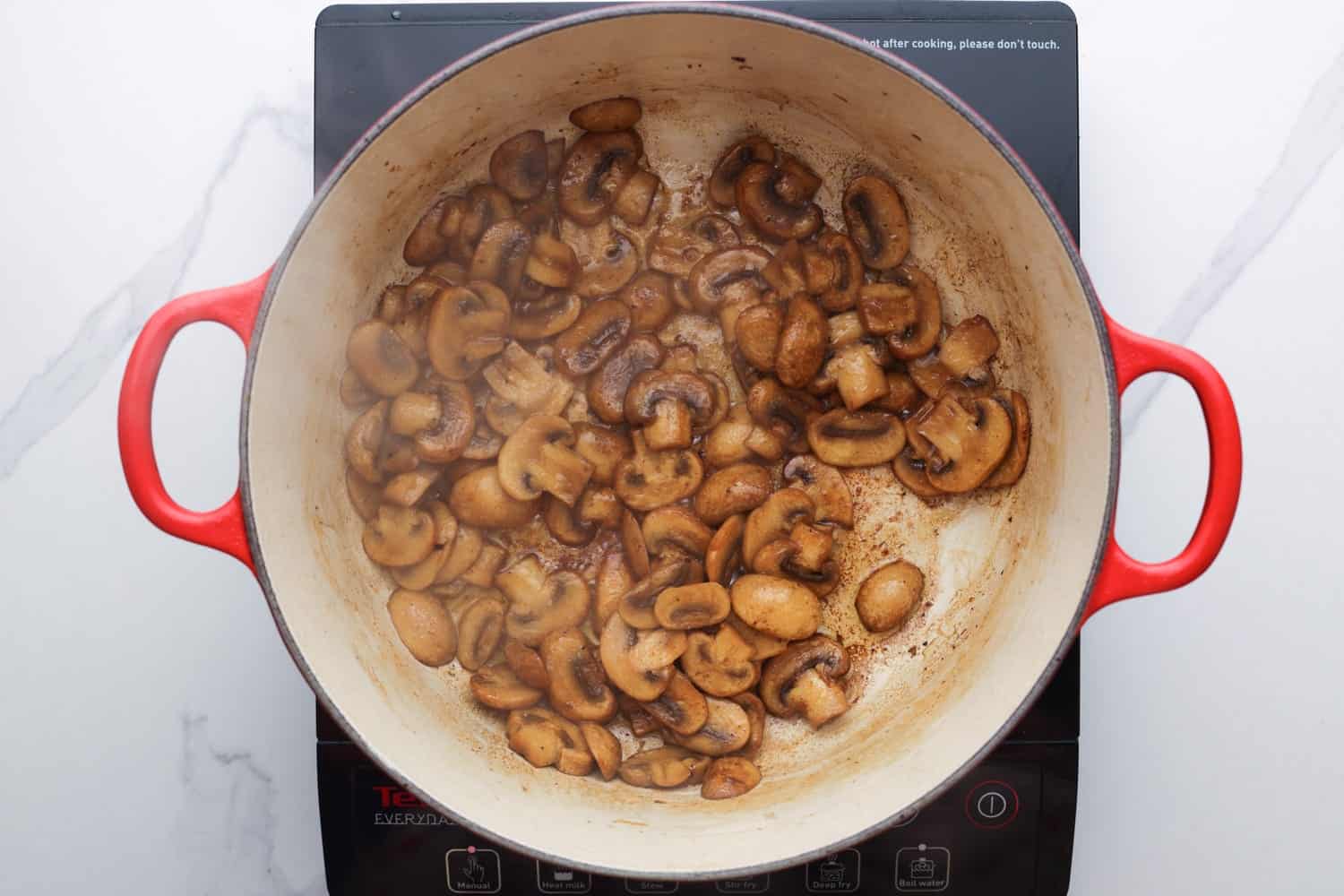browned sliced mushrooms in a dutch oven