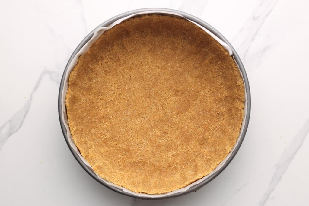 a thick graham cracker crust formed into a springform pan.