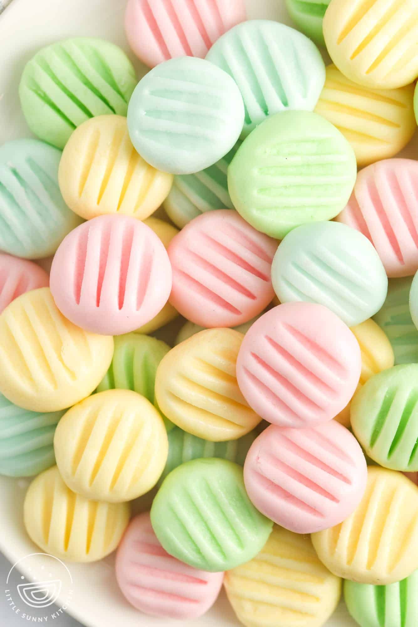 a plate of cream cheese mints in pastel colors.