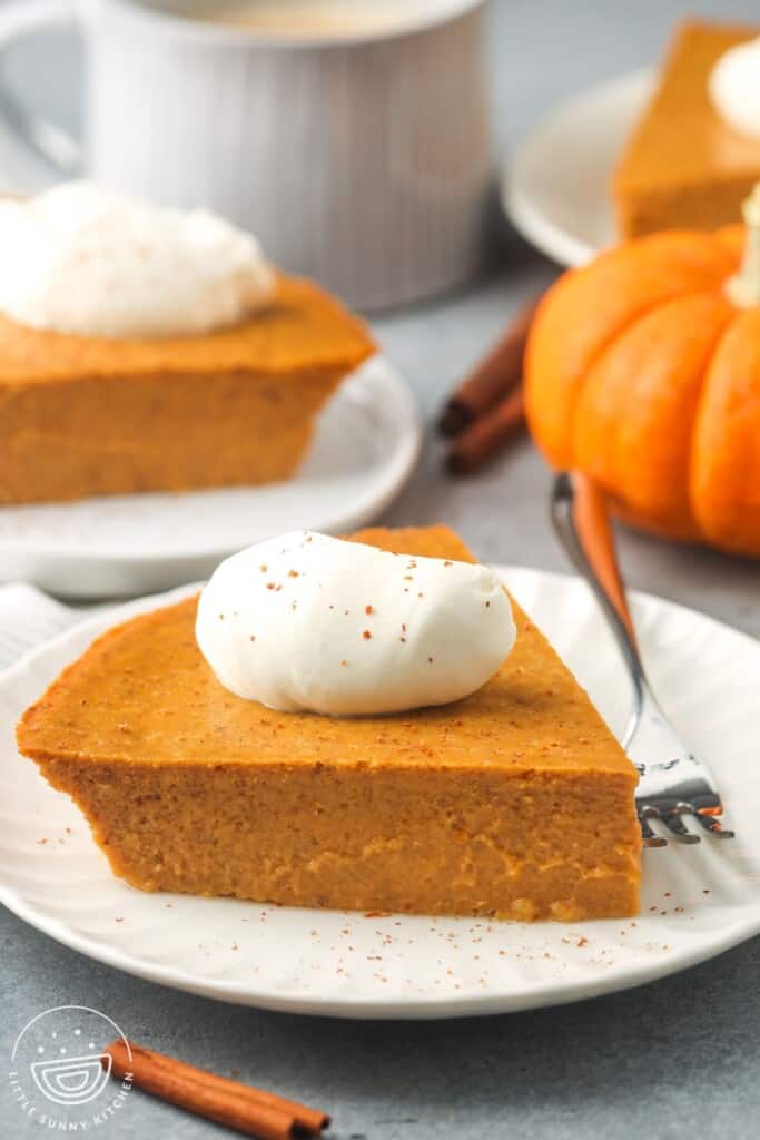slices of pumpkin pie without crust on dessert plates, topped with whipped cream