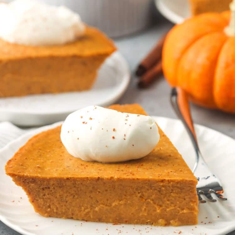 slices of pumpkin pie without crust on dessert plates, topped with whipped cream