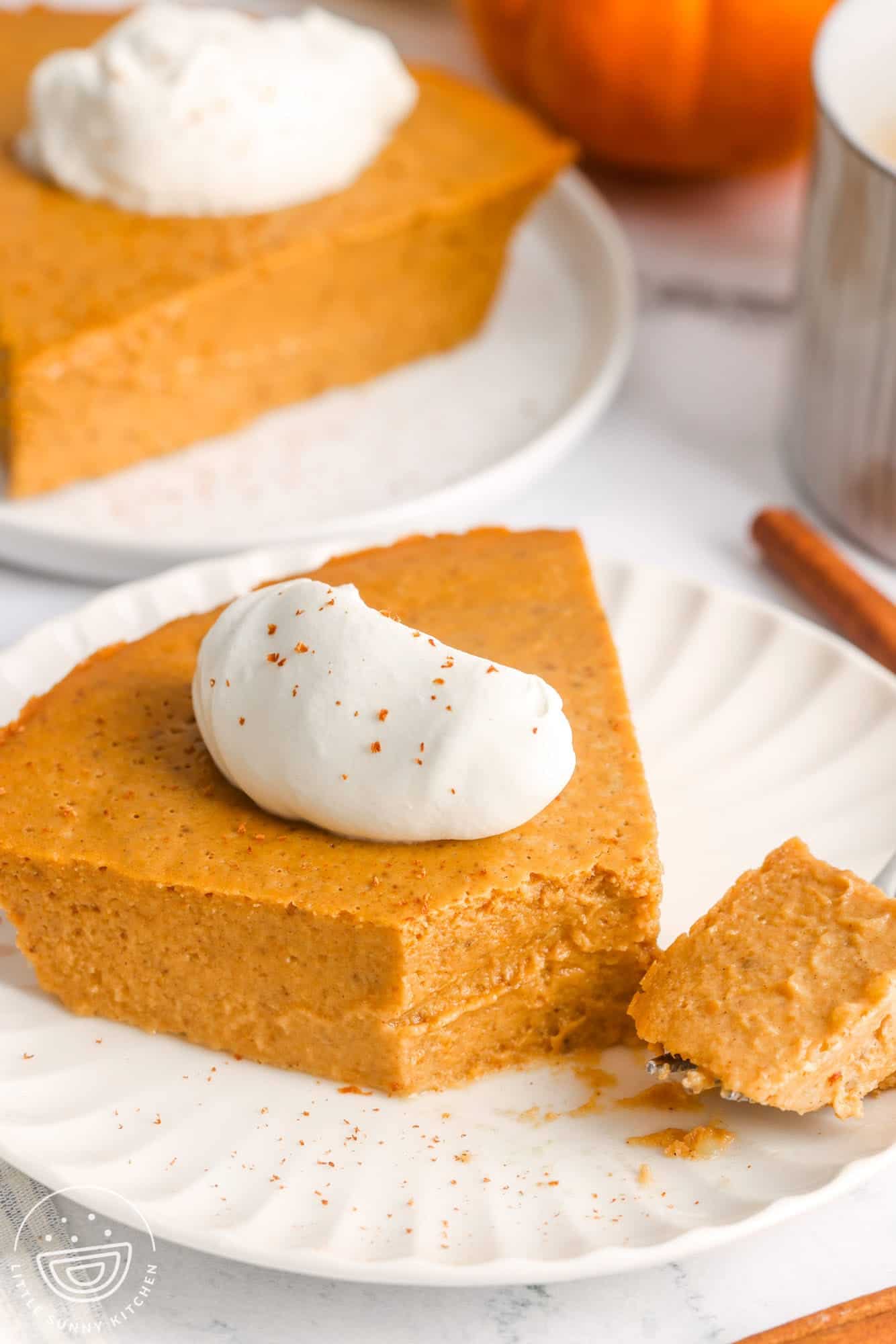 a slice of crustless pumpkin pie on a plate with a bite taken.