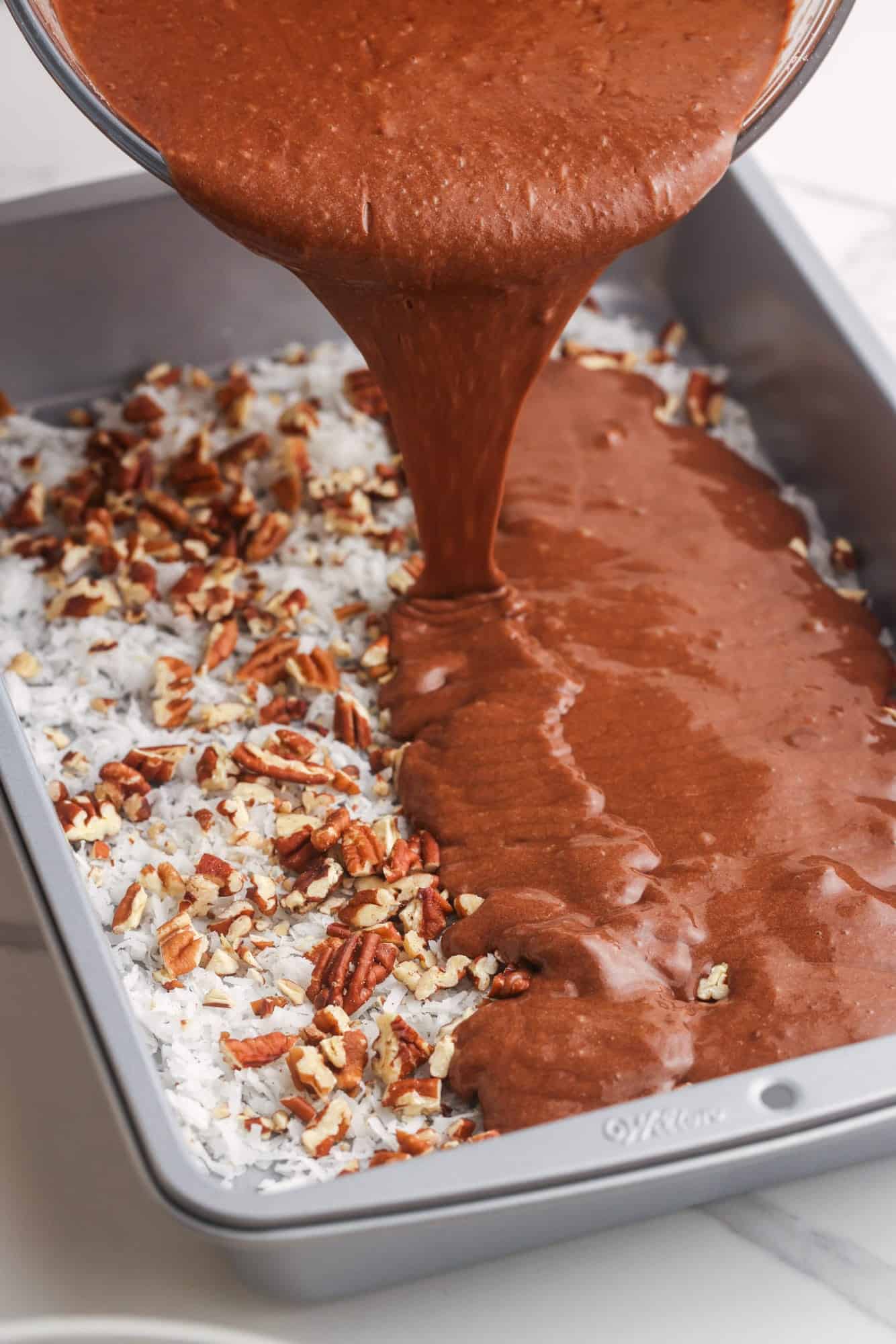 chocolate cake batter poured over coconut and pecans.