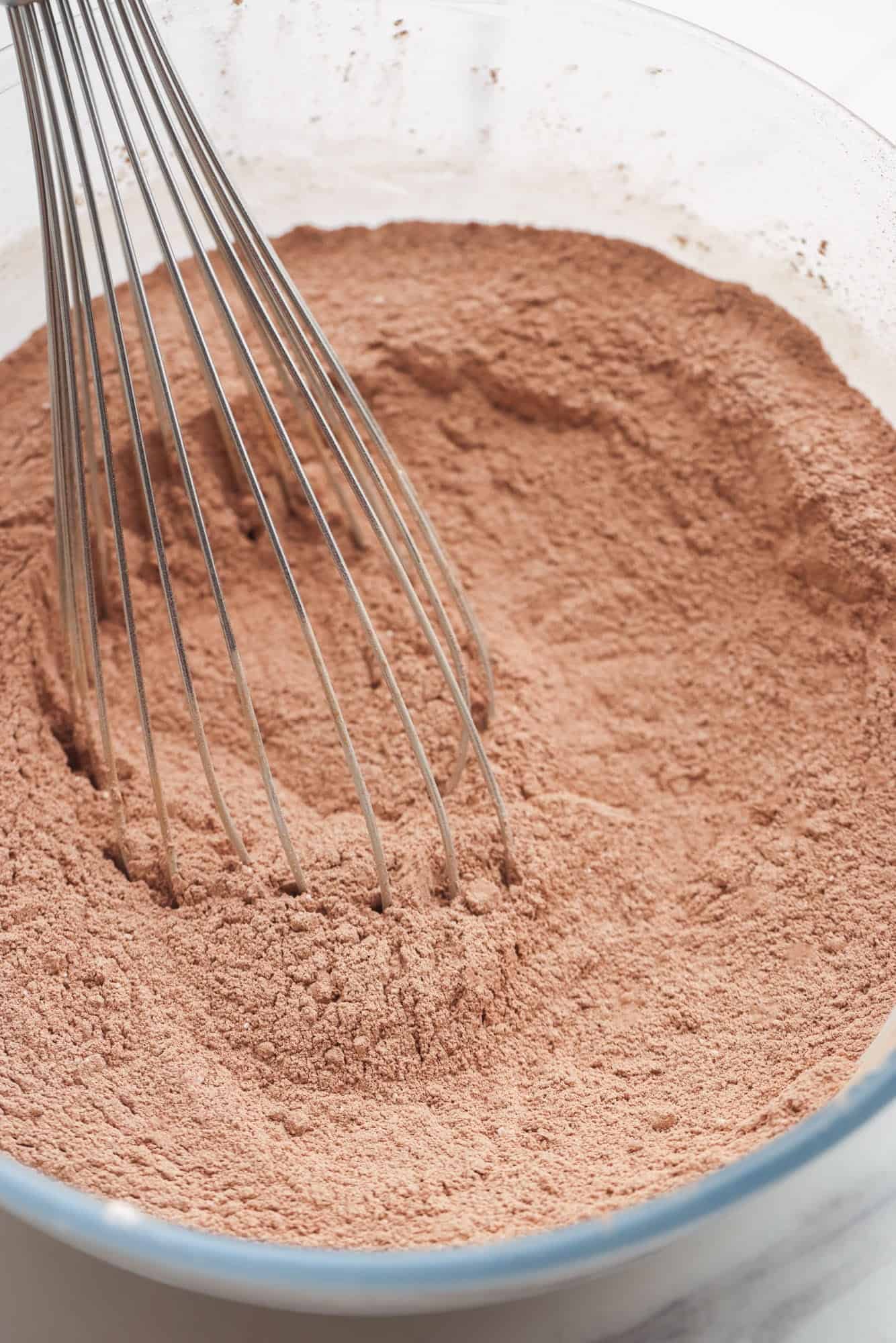 a whisk mixing hot chocolate powder in a bowl