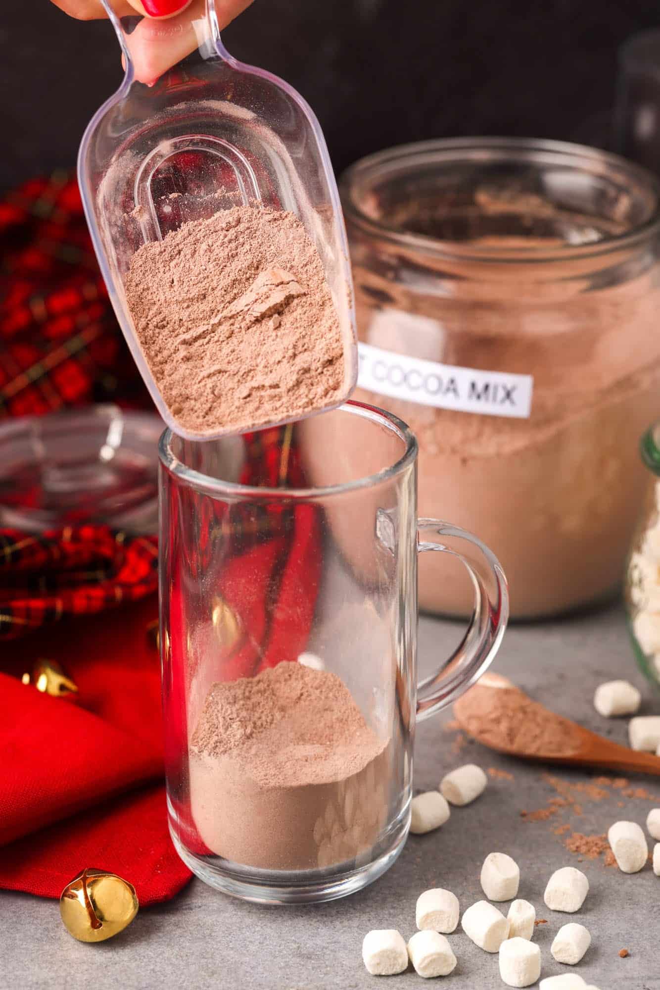 hot cocoa mix added to a mug with a small scoop