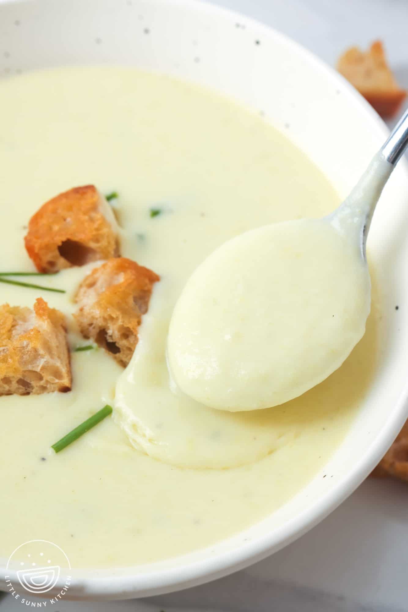 creamy potato leek soup in a bowl topped with croutons.