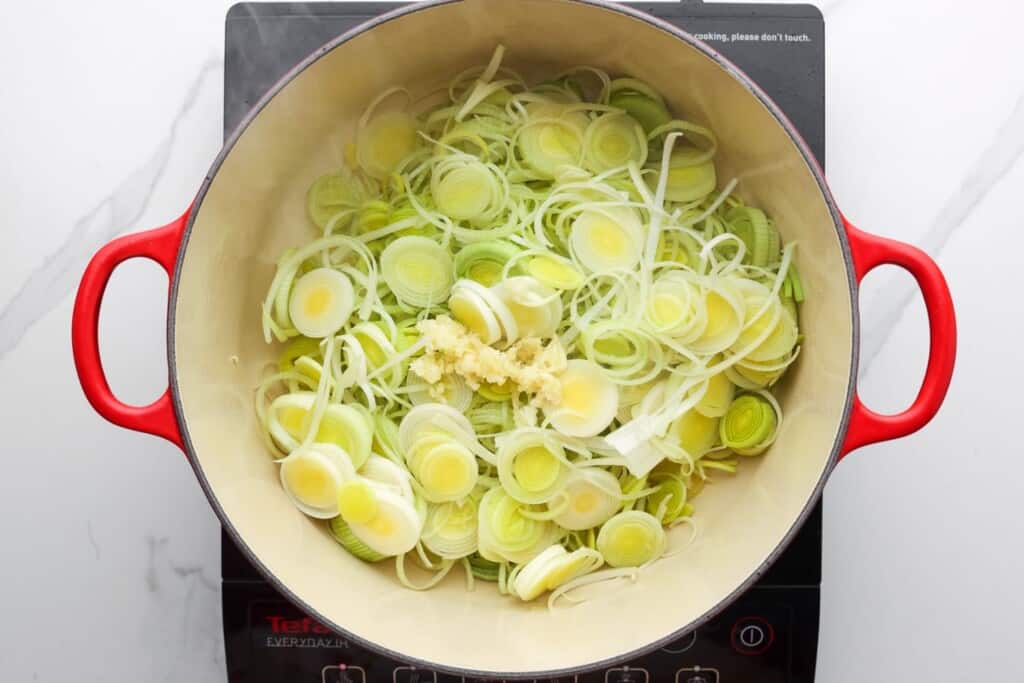 thinly sliced leeks and garlic in a dutch oven.